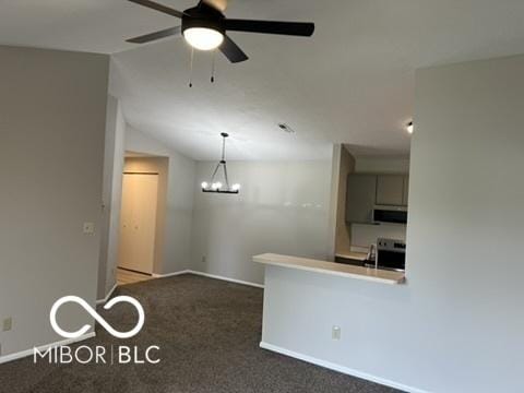 4311 Village Parkway Cir W Unit 6, Indianapolis, IN 46254 - kitchen with exhaust hood, vaulted ceiling, baseboards, carpet flooring, and ceiling fan with notable chandelier