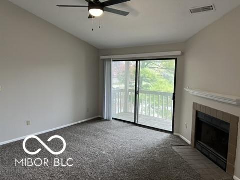 4311 Village Parkway Cir W Unit 6, Indianapolis, IN 46254 - unfurnished living room with carpet, a tile fireplace, visible vents, baseboards, and ceiling fan