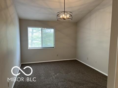 4311 Village Parkway Cir W Unit 6, Indianapolis, IN 46254 - empty room featuring baseboards, carpet flooring, and an inviting chandelier