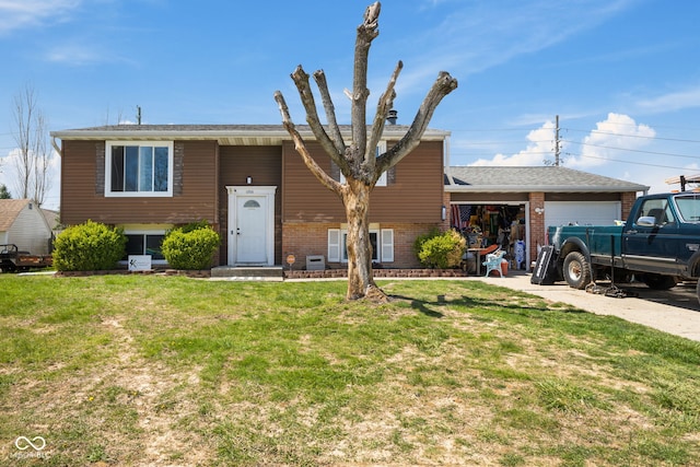 split foyer home featuring an attached garage, driveway, a front lawn, and brick siding