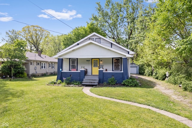 bungalow-style home featuring covered porch, a front lawn, stucco siding, an outdoor structure, and a garage