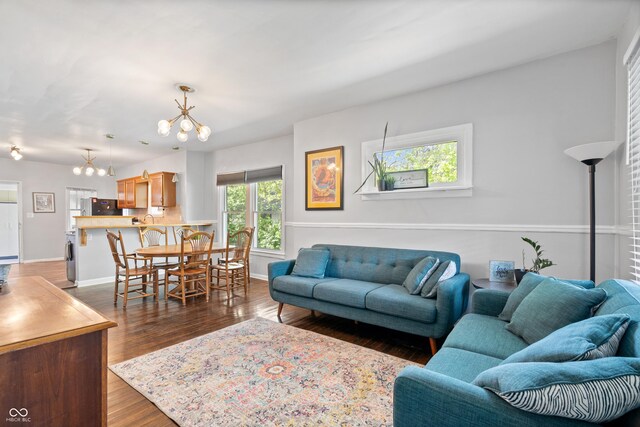 living room with a chandelier, dark wood-style flooring, and baseboards