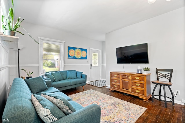 living area with healthy amount of natural light, dark wood-style floors, and baseboards