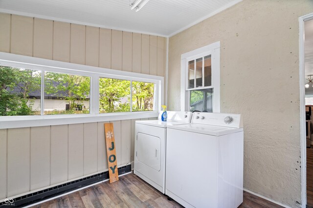 laundry area with washer and clothes dryer, baseboard heating, and wood finished floors