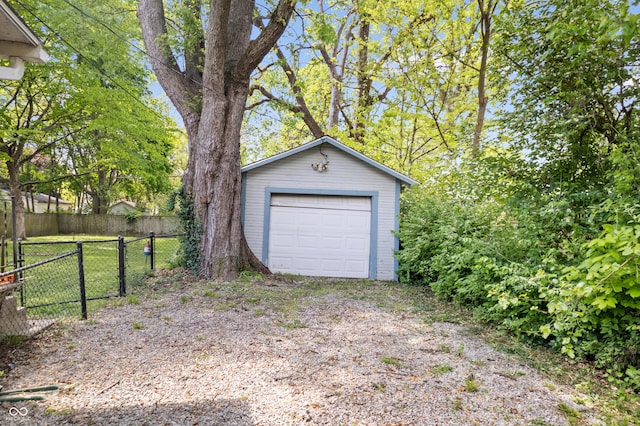 detached garage with fence and driveway