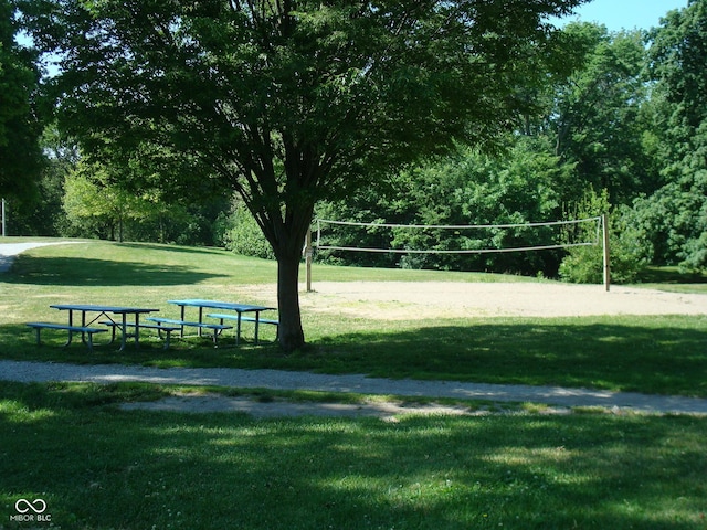 view of home's community with volleyball court and a yard