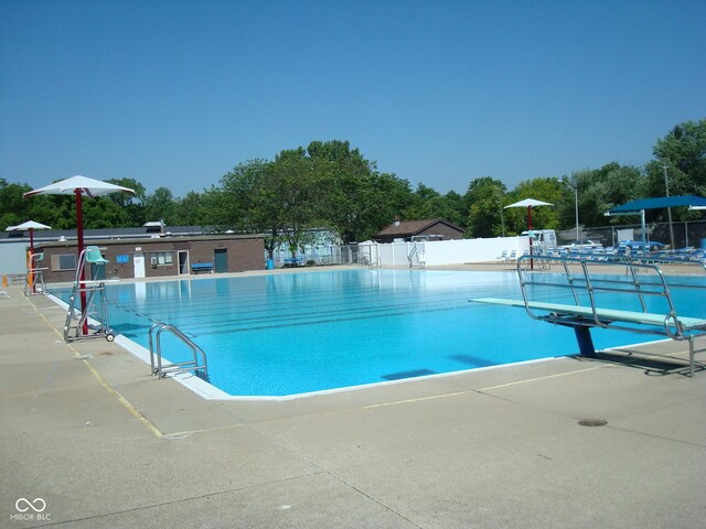 community pool featuring fence and a patio