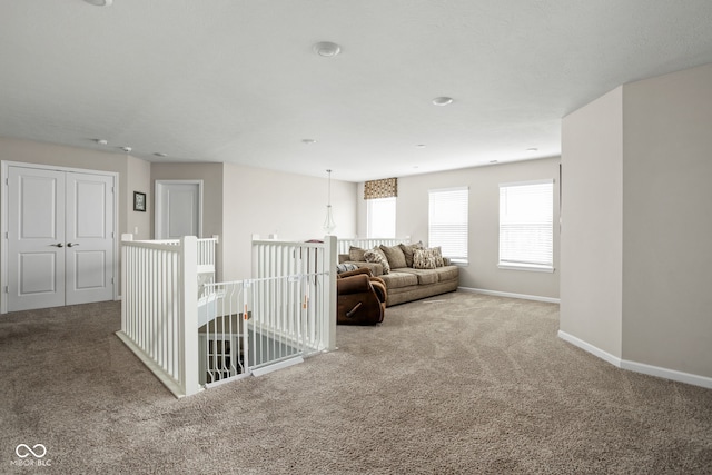 living area featuring baseboards and carpet