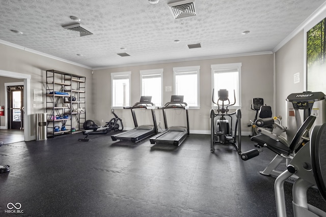 gym with crown molding, a textured ceiling, baseboards, and visible vents
