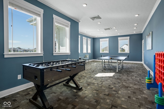 rec room featuring carpet floors, plenty of natural light, ornamental molding, and visible vents