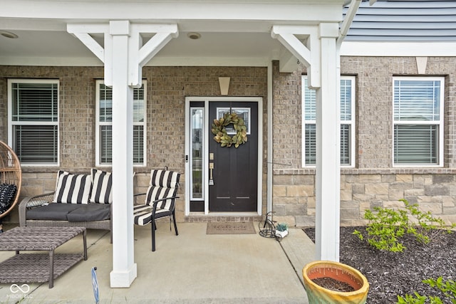 property entrance featuring covered porch and stone siding