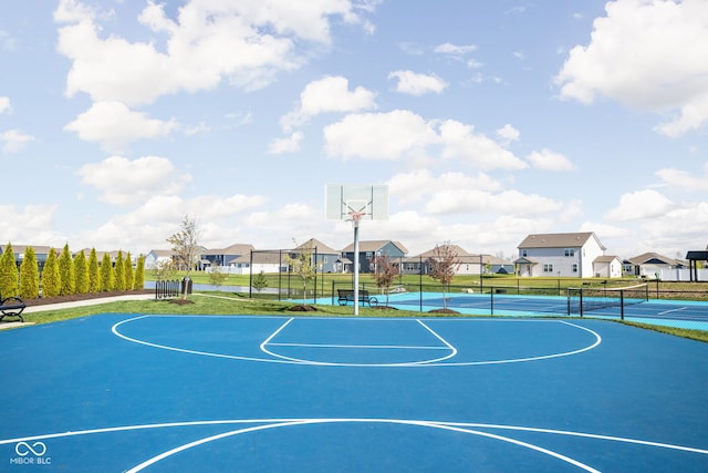 view of basketball court with a residential view, community basketball court, a tennis court, and fence