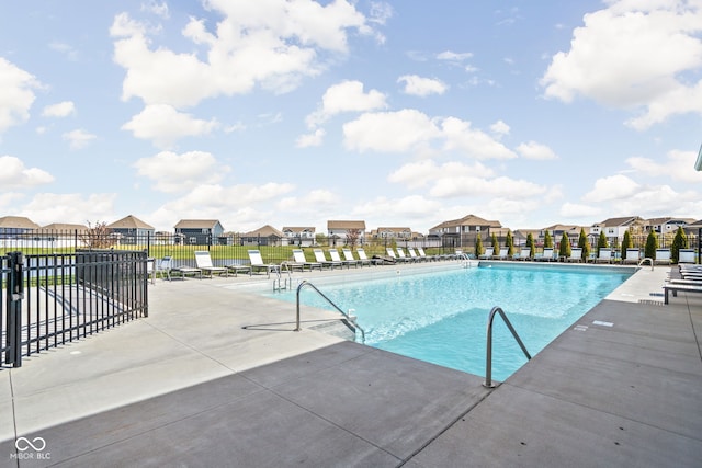 pool featuring a patio area, fence, and a residential view
