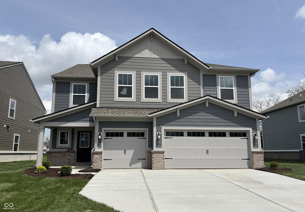 craftsman-style house featuring roof with shingles, an attached garage, a front lawn, a porch, and driveway