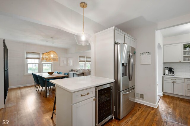 kitchen featuring beverage cooler, stainless steel refrigerator with ice dispenser, dark wood-style floors, tasteful backsplash, and light countertops