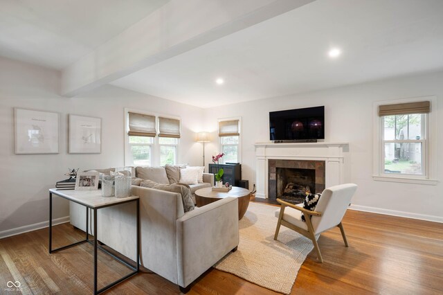living room with healthy amount of natural light, a fireplace, baseboards, wood finished floors, and recessed lighting