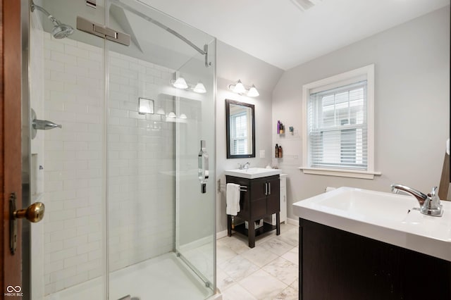 full bath featuring a shower stall, two vanities, and marble finish flooring
