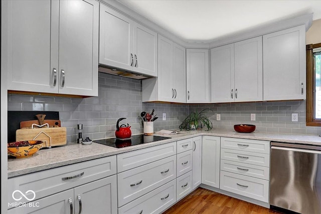 kitchen with black electric cooktop, tasteful backsplash, under cabinet range hood, and dishwasher