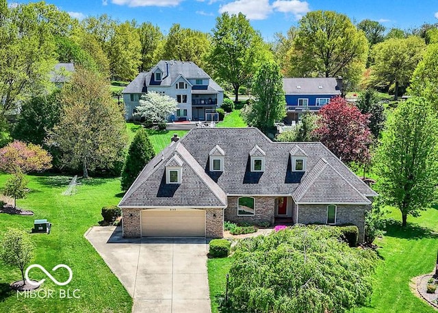 view of front of property with a front yard, roof with shingles, brick siding, an attached garage, and driveway