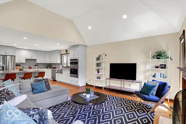 living area featuring light wood-type flooring, recessed lighting, and lofted ceiling