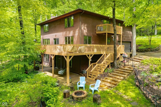 13306 W 50 S, Columbus, IN 47201 - rear view of house with an outdoor fire pit, a patio, a deck, a chimney, and a forest view