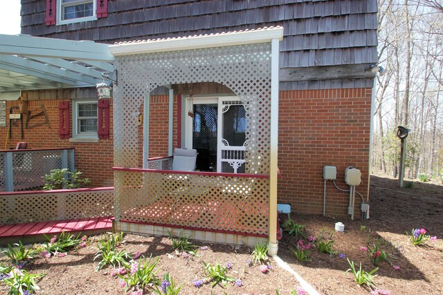 exterior space with brick siding and mansard roof