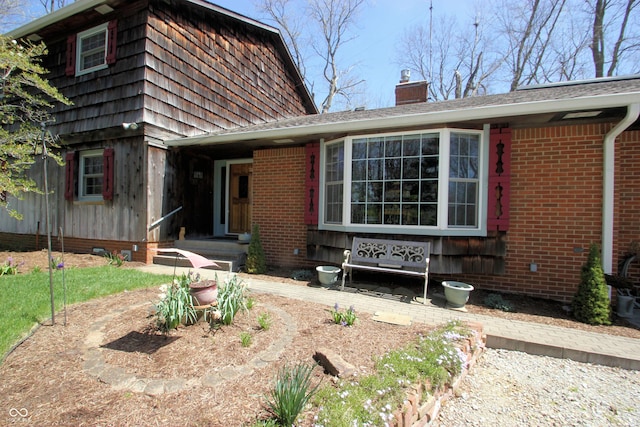 view of front of house with a chimney and brick siding