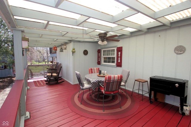 wooden deck featuring a pergola, outdoor dining space, and a ceiling fan