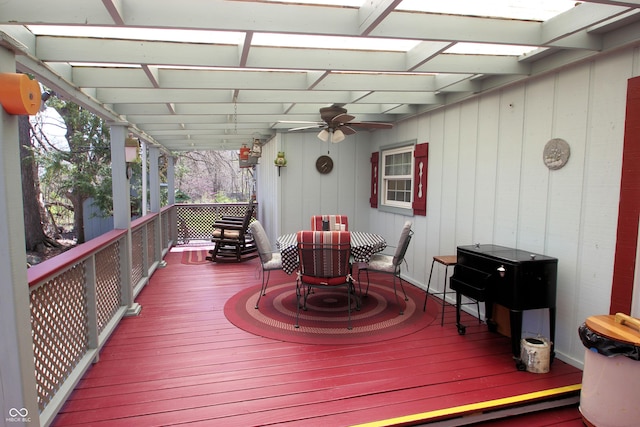 wooden terrace with outdoor dining area, a pergola, and ceiling fan