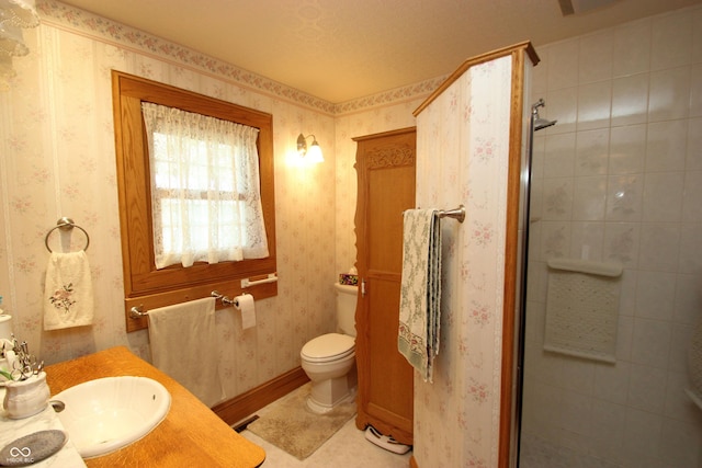 bathroom with a shower stall, vanity, toilet, and wallpapered walls