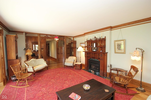 living room with a wood stove, ornamental molding, and wood finished floors