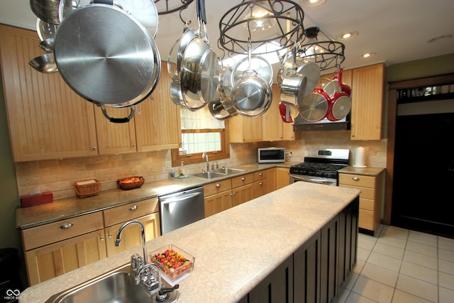 kitchen featuring backsplash, appliances with stainless steel finishes, light brown cabinetry, and a sink