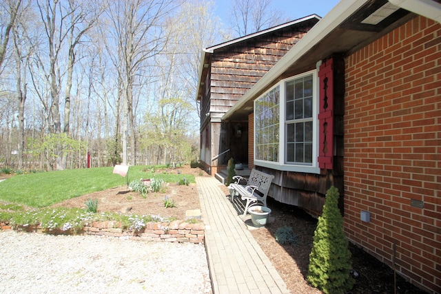 view of home's exterior with brick siding and a lawn