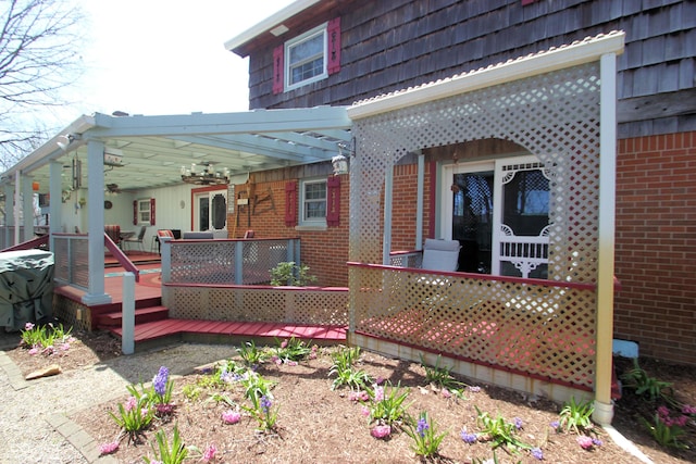 back of house with brick siding, a wooden deck, and ceiling fan