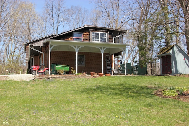 view of front of home with an outbuilding, brick siding, and a front lawn