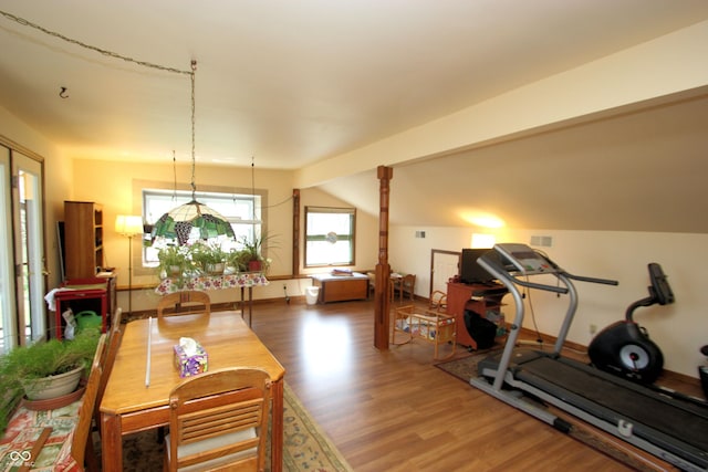 interior space with baseboards, wood finished floors, and lofted ceiling