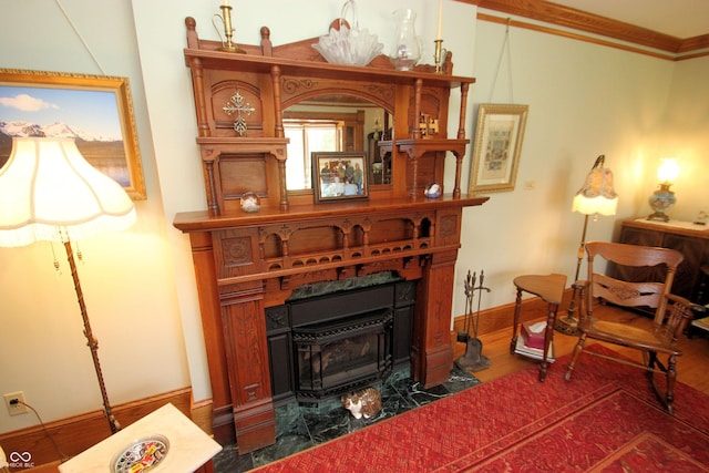 sitting room with baseboards, crown molding, and wood finished floors