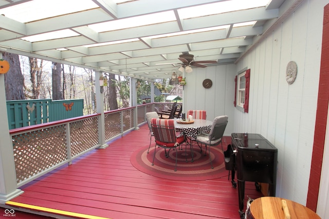 wooden terrace featuring outdoor dining space and a ceiling fan