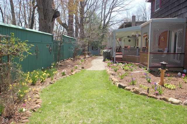 view of yard featuring a ceiling fan and a wooden deck