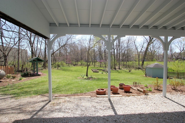 view of yard featuring an outbuilding, a shed, and fence