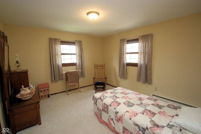 bedroom featuring a baseboard heating unit, multiple windows, baseboards, and light colored carpet