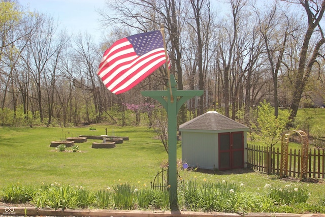 view of yard with an outbuilding, fence, and a storage unit