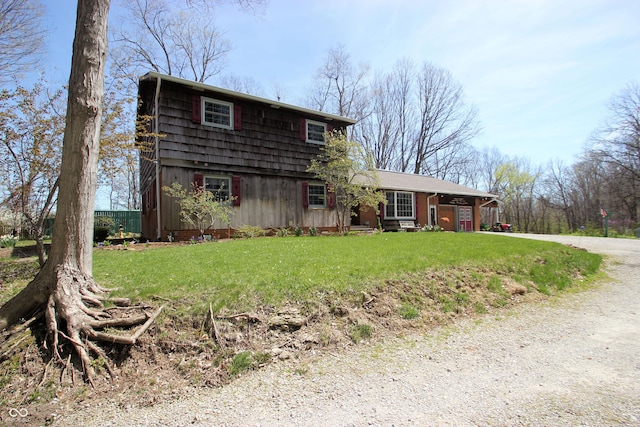view of front of home featuring dirt driveway and a front yard