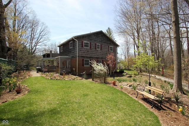 rear view of house with a lawn and a wooden deck