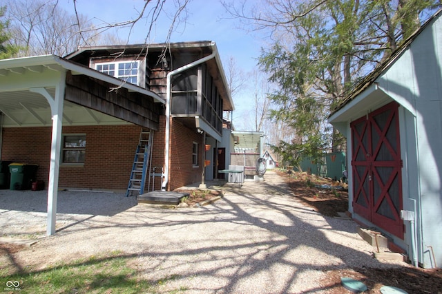 view of home's exterior featuring brick siding and a carport