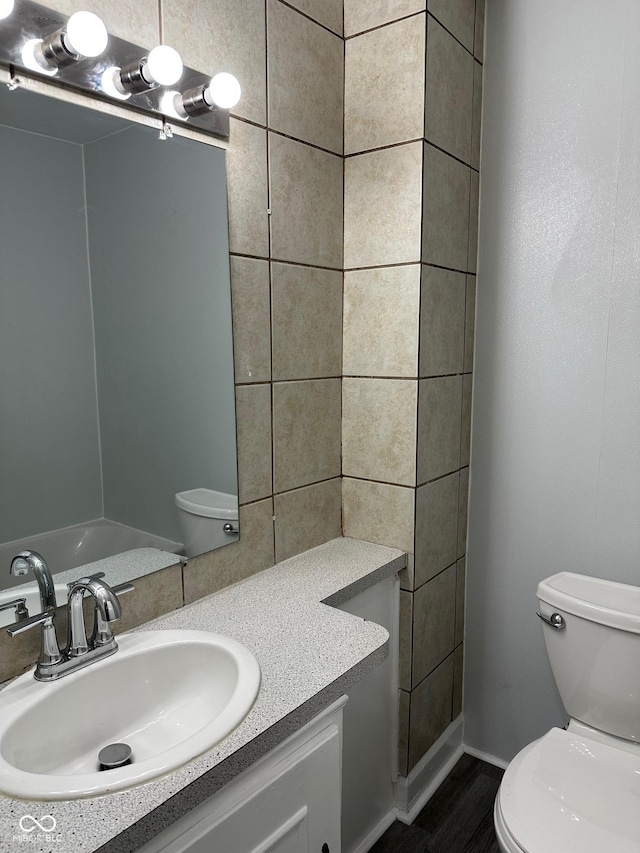 bathroom featuring wood finished floors, vanity, and toilet