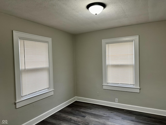 unfurnished room featuring baseboards, a textured ceiling, and dark wood-style flooring