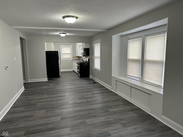 interior space with white cabinets, baseboards, gas stove, and freestanding refrigerator