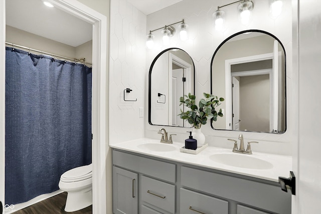 132 Oakhurst Way, Westfield, IN 46074 - bathroom featuring a sink, toilet, double vanity, and wood finished floors