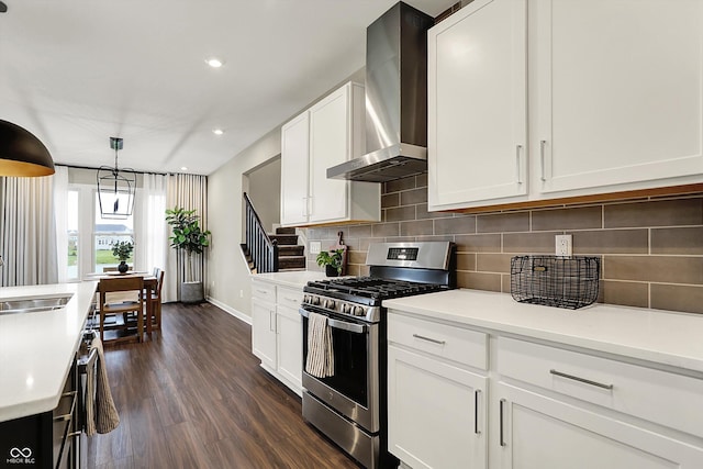 132 Oakhurst Way, Westfield, IN 46074 - kitchen with wall chimney range hood, dark wood-style flooring, stainless steel range with gas stovetop, light countertops, and baseboards